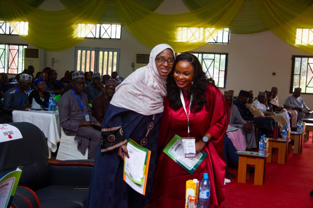 Two participants sharing a warm moment during an institutional gathering